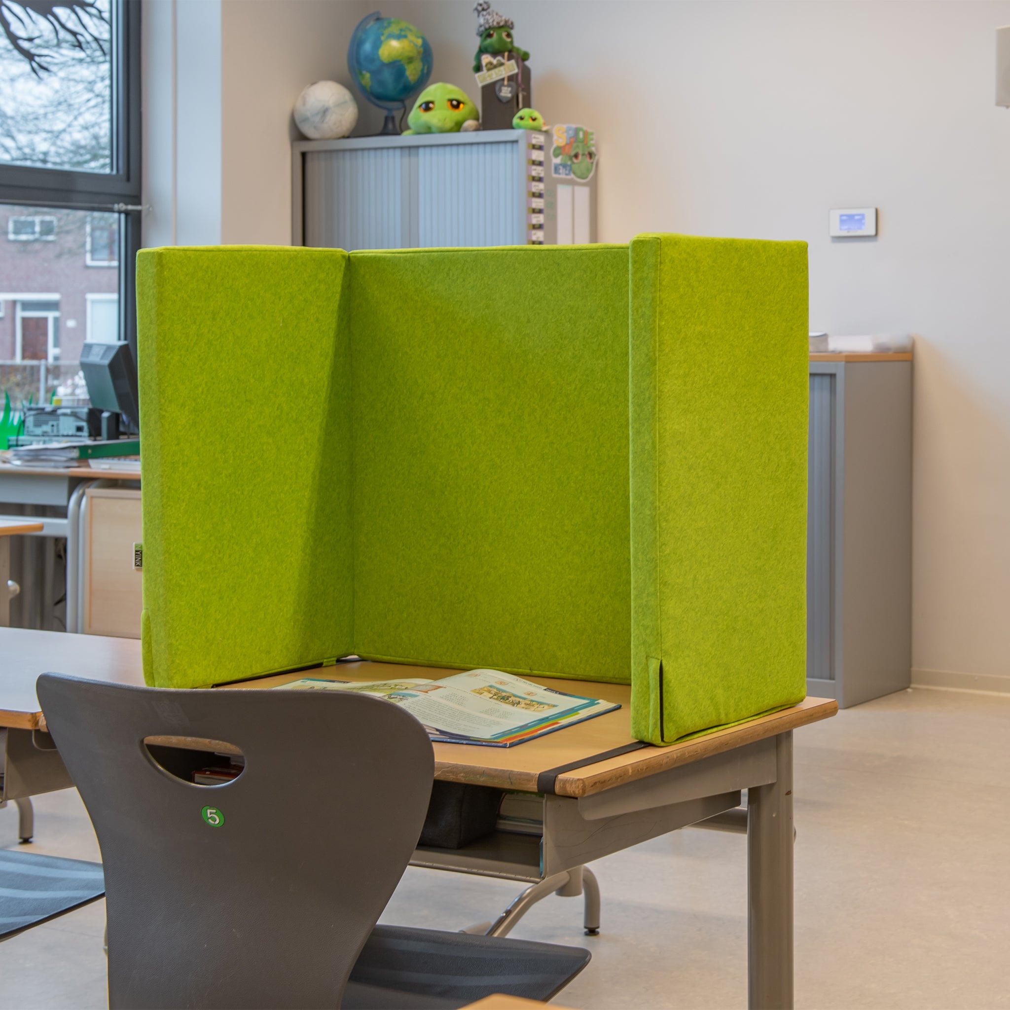 Concentratiescherm groen klaslokaal voor op een leerling tafel.