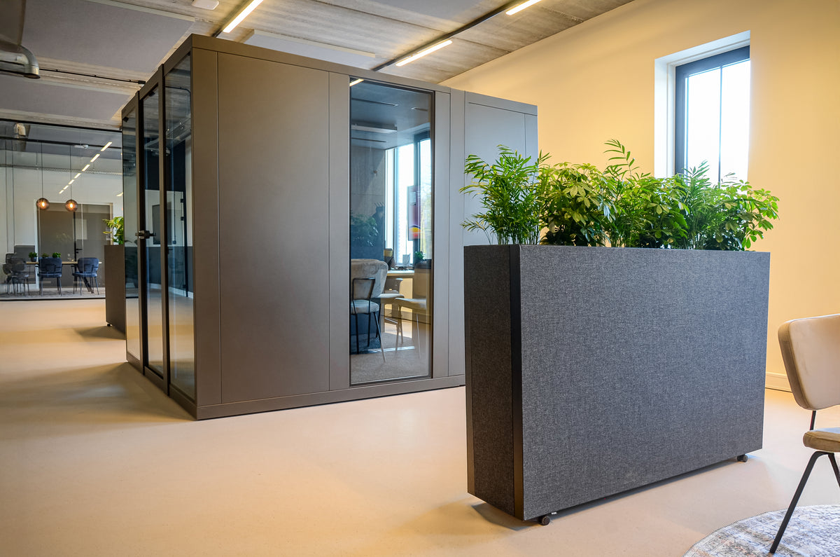 ruimte met een akoestische plantenbak en een vergaderbox erin.