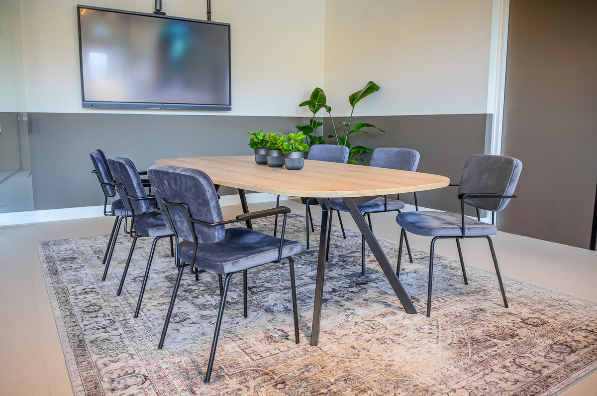 Vergaderruimte met een vergadertafel en stoelen. 